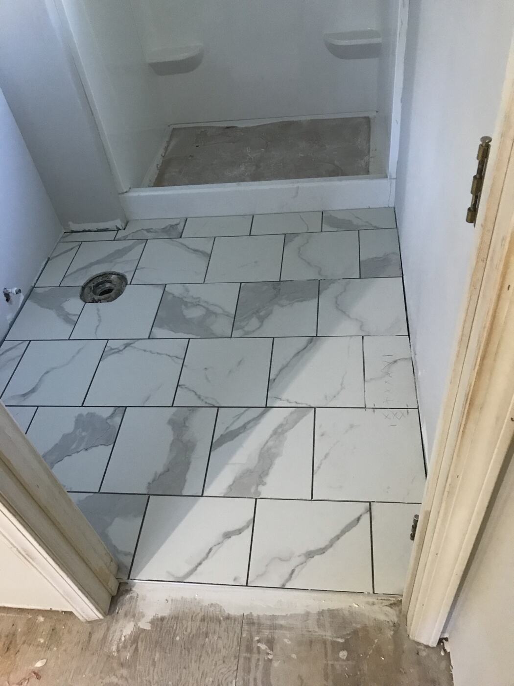 Bathroom floor and shower finished in marble-look tile